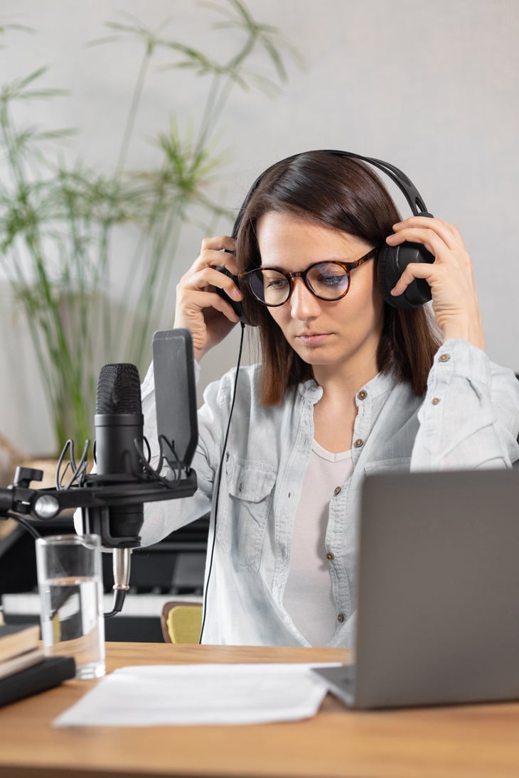 podcast, audio content creation. a beautiful European woman podcaster or radio host records a podcast or content in a recording studio